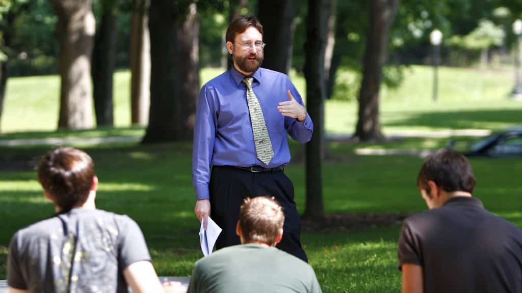 Dr. Gavin Weaire teaching a class outside on the lawn.