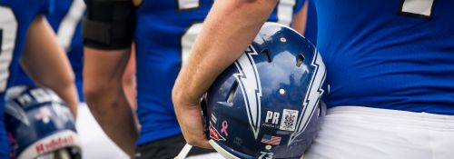 Hillsdale football players holding helmets