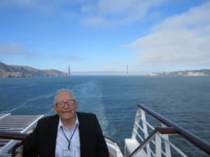 Golden Gate bridge in background of cruise ship.