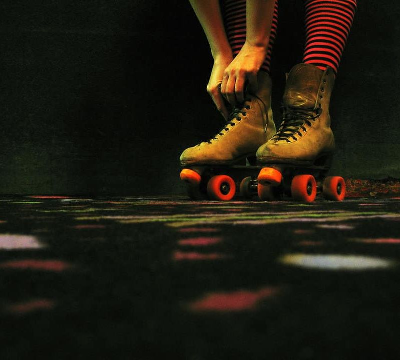 A woman tying her roller skate laces.