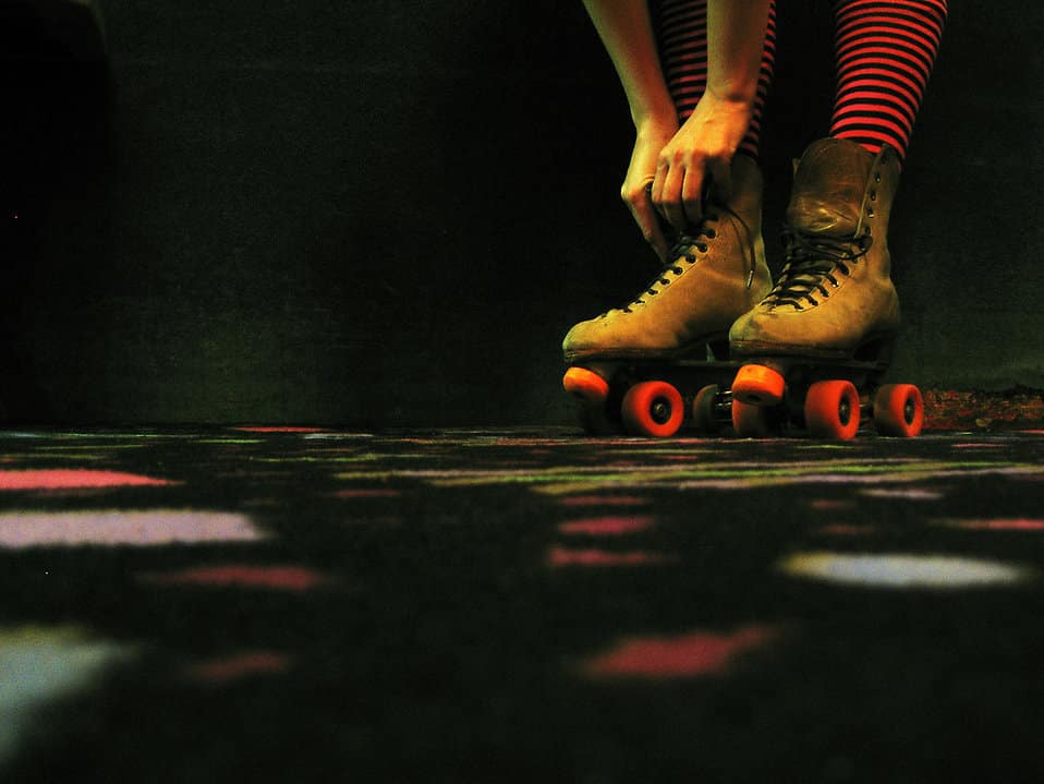A woman tying her roller skate laces.
