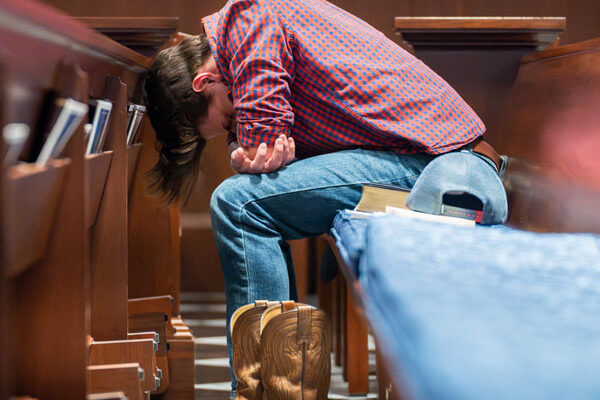 A retreat participant bows his head in prayer.