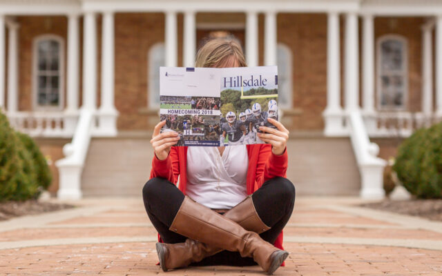 A student reading the alumni magazine.